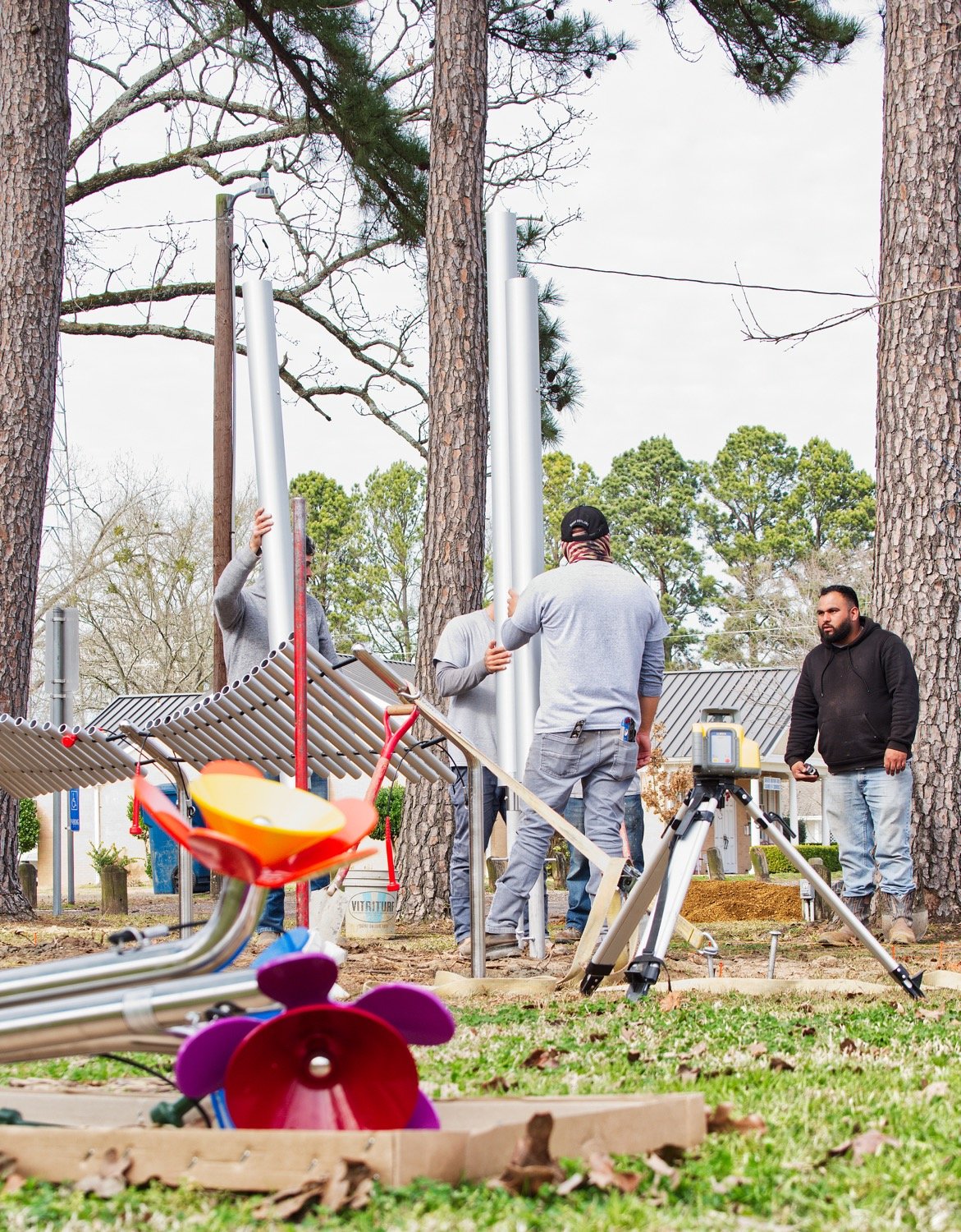 Workers install chimes in the Jim Hogg City Park in Quitman as part of the new play installation featuring a variety of musical instruments.